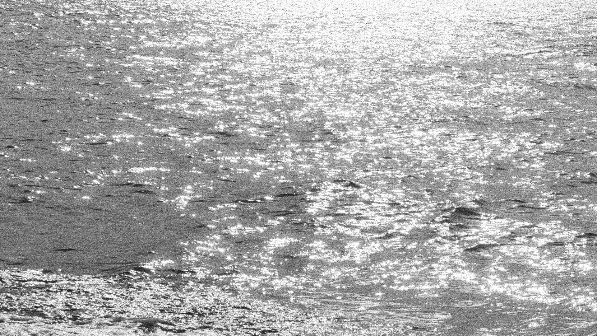 Black and white background image of shimmering body of water